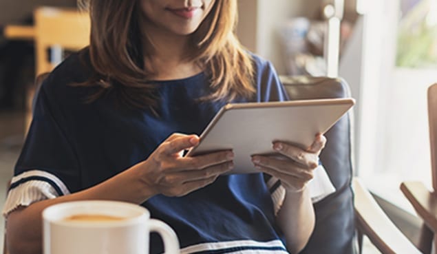 woman in cafe looking for an it consultant on her tablet