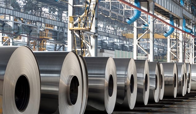 rolls of steel on ground of warehouse that uses it company