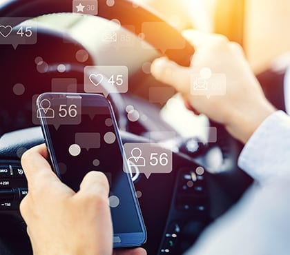 man in car looking at notifications from it consultant on phone