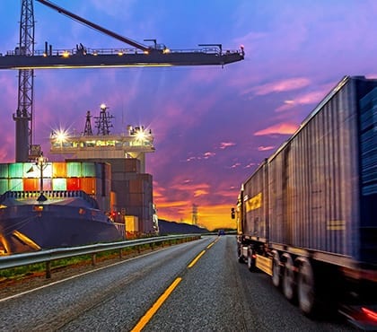 truck driving past shipping container yard